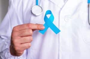 Un urologue qui montre un ruban bleu, symbole de la lutte contre le cancer de la prostate