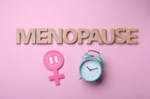 Une affiche rose où est écrit le mot ménopause