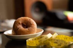 Un donut symbole du gras et un mètre symbole du tour de taille